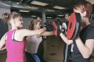 3 people participating in boxing training