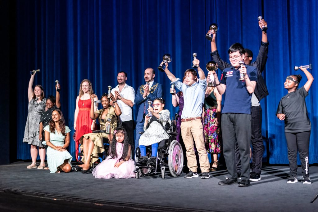 Dance Westminster finalists on stage at the Odeon cinema, cheering with their trophies.