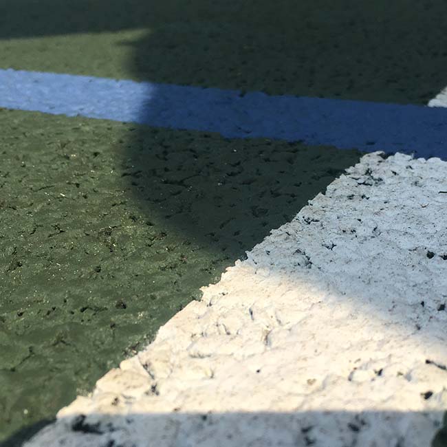 close-up image of tarmac court surface coloured green