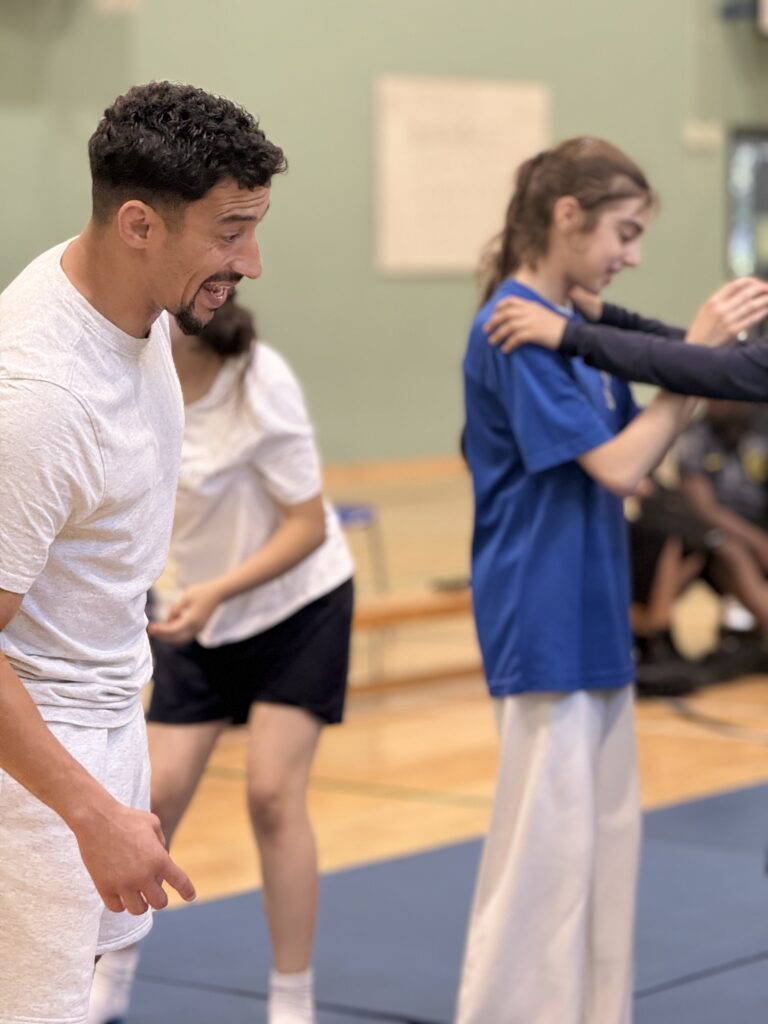 AW CotF & Ambassador Ashley Mckenzie watching the children trying the Judo moves he demod