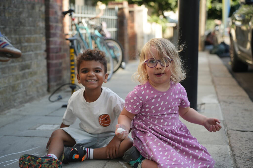 Ashmore Rd Play Day Play Street - Little boy and girl sitting on the road next to each other